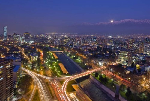 a city at night with a river and a bridge