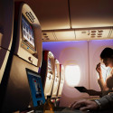 a woman using a laptop on an airplane