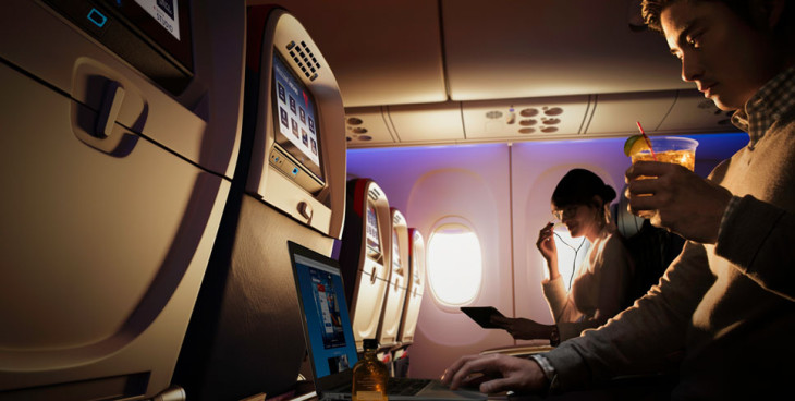 a woman using a laptop in an airplane