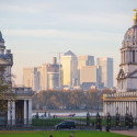 a park with a large building and a city in the background