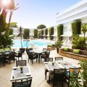 a restaurant with tables and chairs around a pool