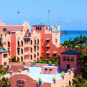 a pink building with a blue sky and water in the background with Don CeSar in the background