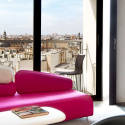 a pink couch in a room with a view of a city