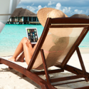 a woman sitting on a beach chair with a laptop