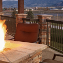 a fire pit with a chair and a mountain in the background