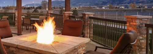 a fire pit with a chair and a mountain in the background