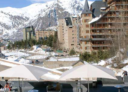 a snowy mountain landscape with buildings and trees