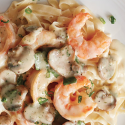 a plate of pasta with shrimp and mushrooms