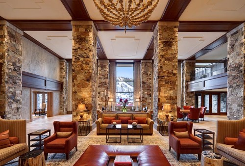 a large room with stone pillars and a chandelier