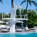 a pool with a white tower and chairs