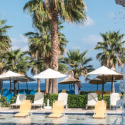 a pool with umbrellas and chairs by the water