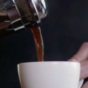 a person pouring coffee into a cup