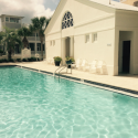 a pool with chairs and a building