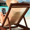 a woman sitting in a chair on a beach with a laptop