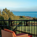 a chair on a balcony overlooking a golf course