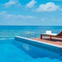 a pool with a deck chair and a railing