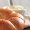 a close up of a bagel and a bowl of cream cheese
