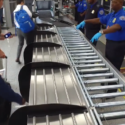 a group of people standing next to a conveyor belt