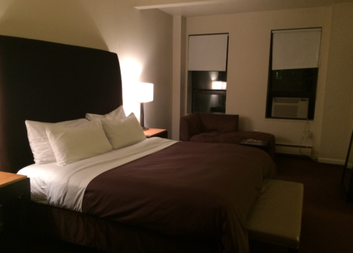 a bed with a brown headboard and a brown chair