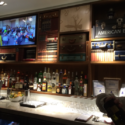 a bar with a television and shelves of liquor