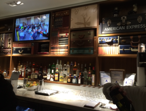 a bar with a television and shelves of liquor