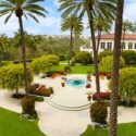 a courtyard with palm trees and a building