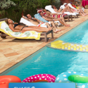 a group of people lying on lounge chairs by a pool