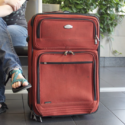 a person sitting next to a suitcase