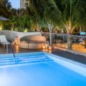 a pool with a deck and palm trees