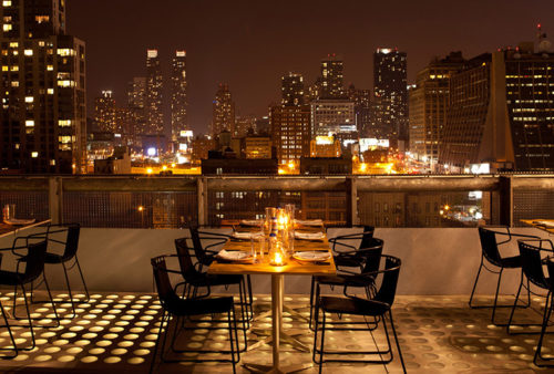 a table with chairs and plates on it with a city in the background