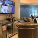 a bar with a television and bottles on the wall