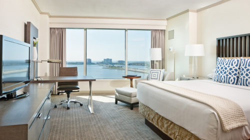 a room with a large window and a bed and a table