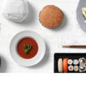 a plate of food and chopsticks on a white surface