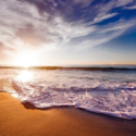 a beach with waves and a blue sky