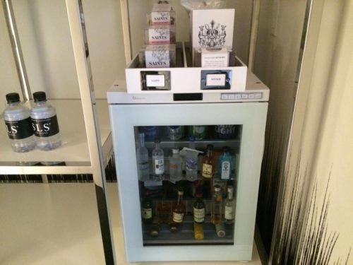 a small refrigerator with bottles of alcohol on top
