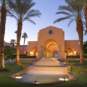 a building with a fountain and palm trees