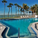 a pool with palm trees and a fence