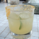 a glass with a drink and a lime on top