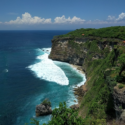 a cliff with a body of water and a road