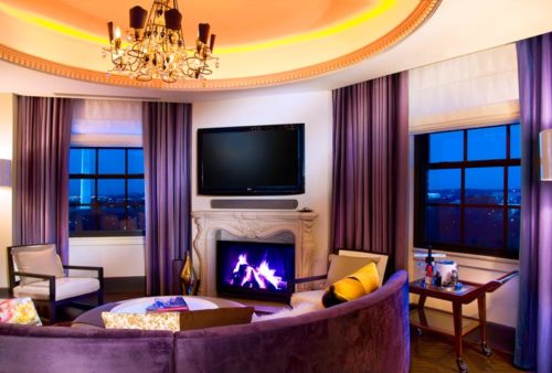 a living room with purple couch and a fireplace