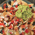 a plate of nachos with guacamole and sauce