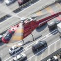 a helicopter flying over a road with cars