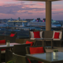 a deck with chairs and a cruise ship in the background