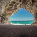 a cave with a beach and water in the background