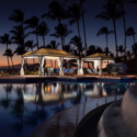 a pool with a gazebo and palm trees