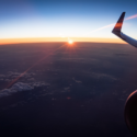 an airplane wing and the sun