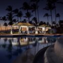 a pool with a gazebo and palm trees