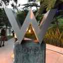 a large metal sign with a letter w on a stone block