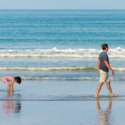 a man and child walking on a beach