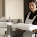 a maid holding a stack of towels